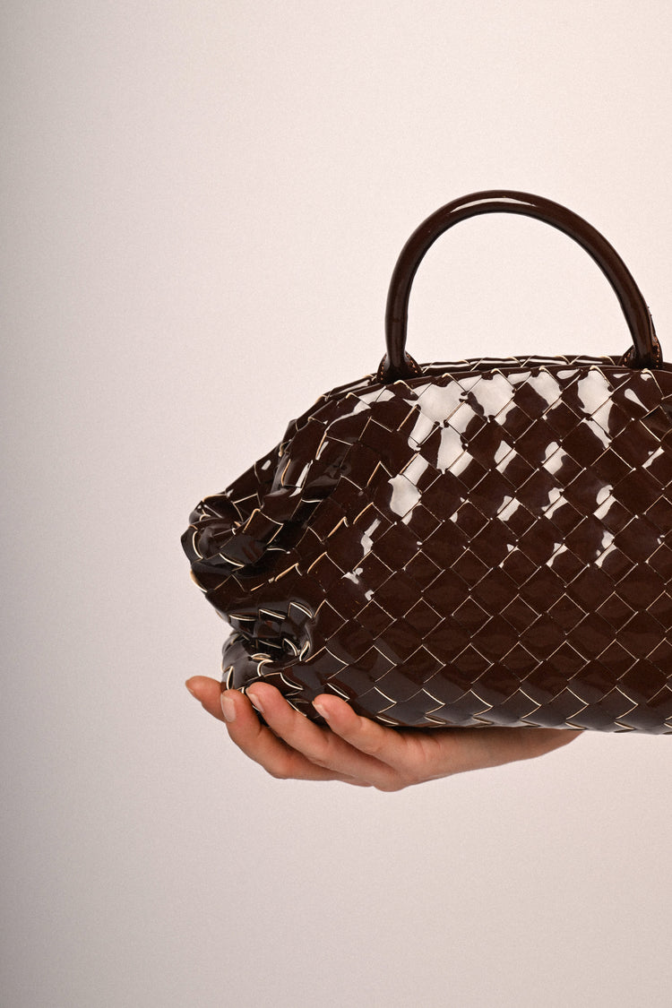 Woven motif faux patent leather handbag